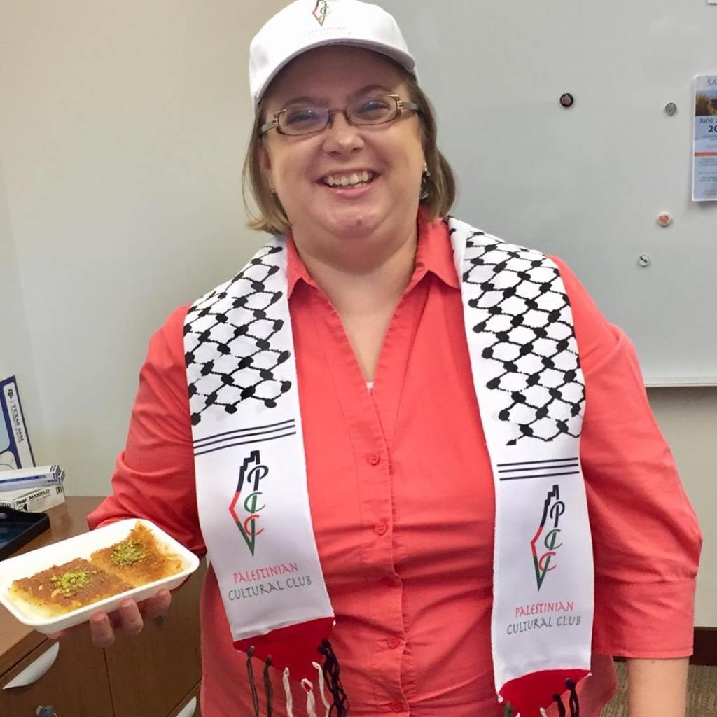 Amy holding food at Palestinian Cultural Club event